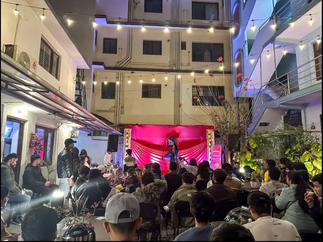 A performer on stage before a full crowd at a Karwaan open-mic night in Kathmandu